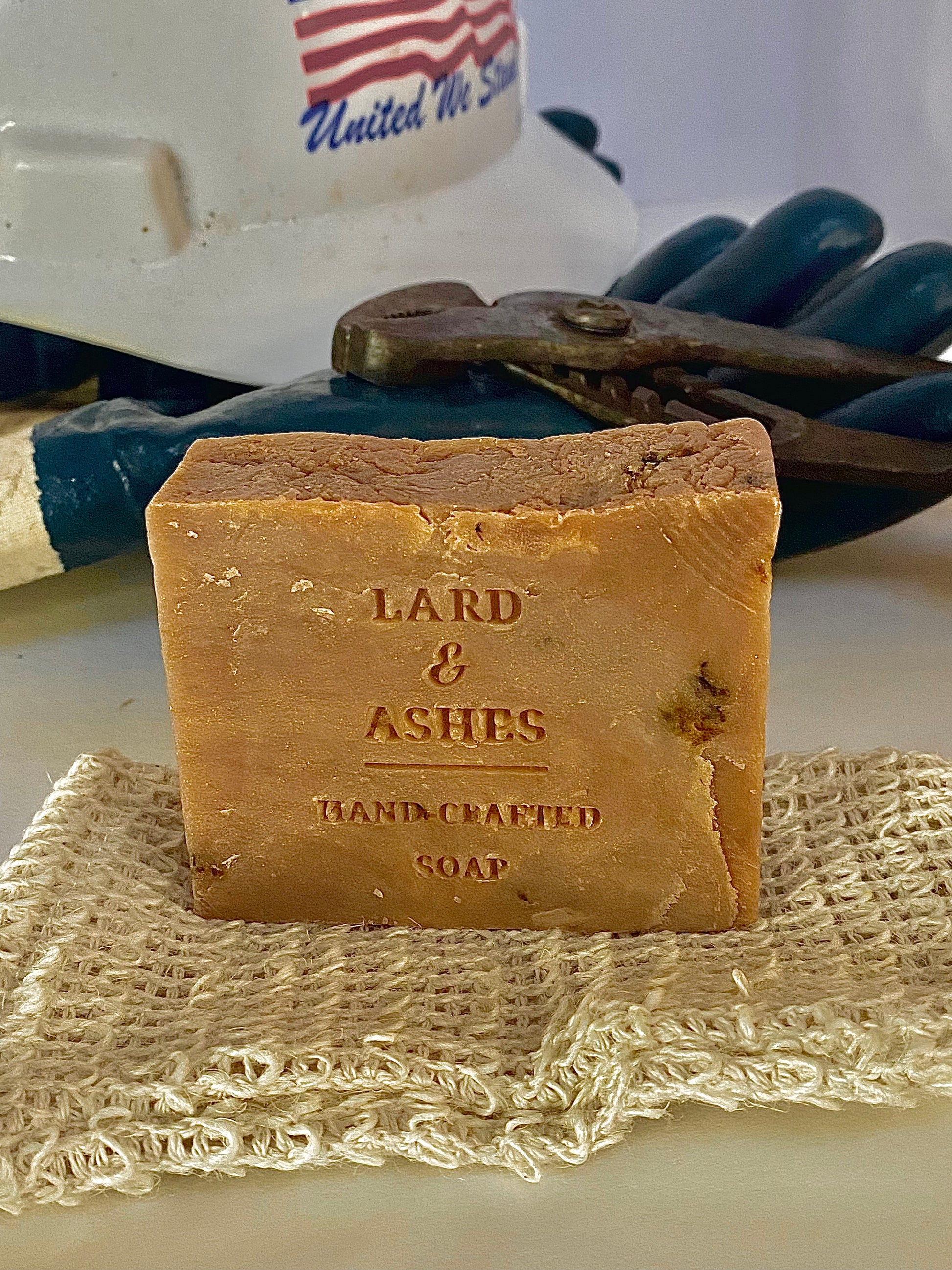 A Lard and Ashes handmade soap bar for man on top of soap bag
